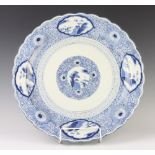 A Chinese blue and white charger with panels of landscape studies 47cm This charger has some contact