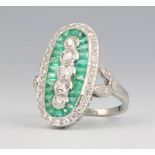 A platinum Art Deco style emerald and diamond up finger ring with 5 brilliant cut diamonds