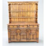 A 17th Century style carved oak dresser, the raised back fitted 2 shelves, base fitted 3 drawers