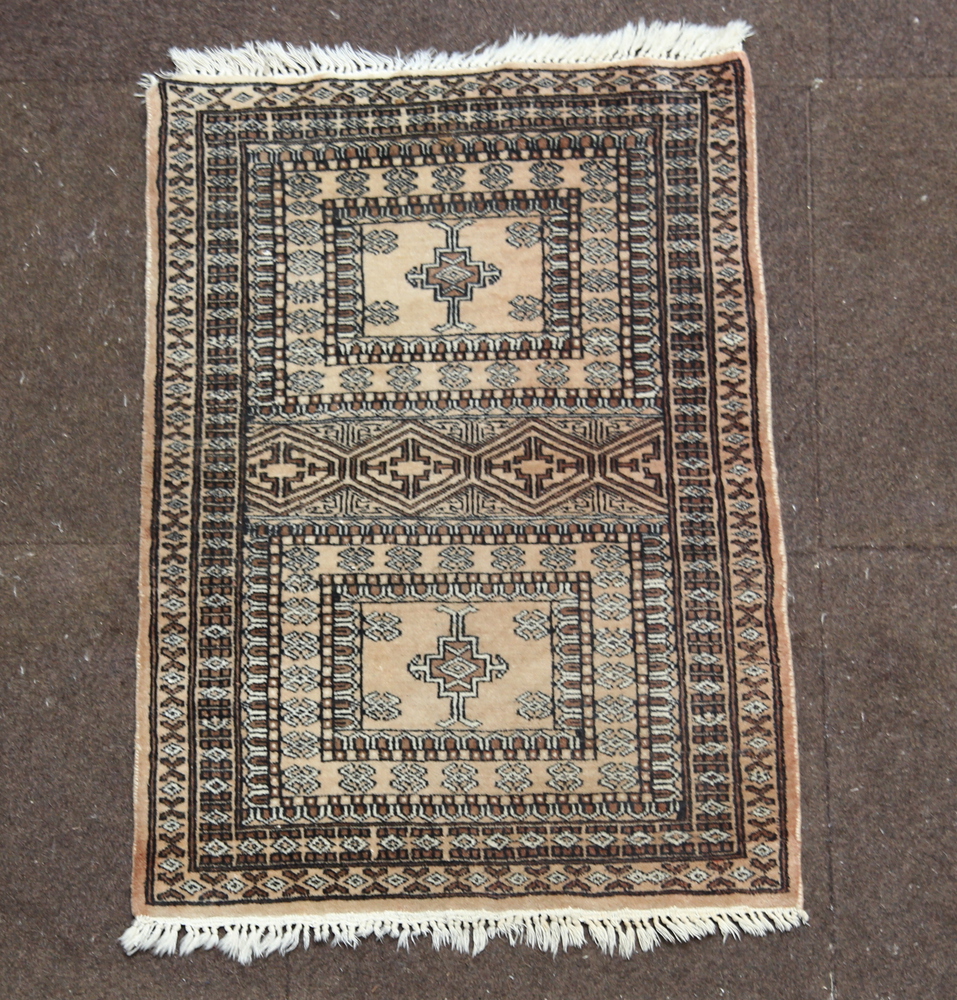 A white and black ground Bokhara rug, 2 panels to the centre within a multirow border 88cm x 62cm