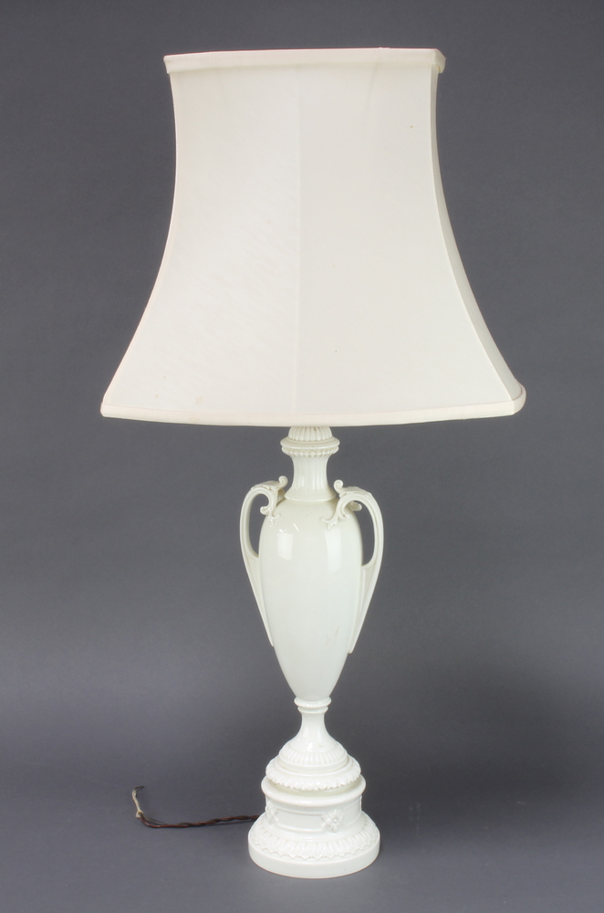 A Royal Worcester white glazed table lamp in the form of a twin handled urn, raised on a circular