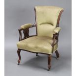 An Edwardian Art Nouveau mahogany open armchair, the seat and back upholstered in green material