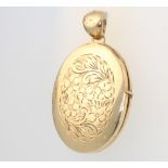 A 9ct yellow gold engraved oval locket, gross 12 grams