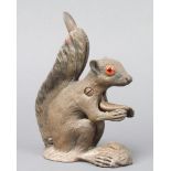 A cast metal nut cracker in the form of a seated squirrel with glass eyes 18cm h x 6cm x 13cm