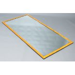 An Art Deco style rectangular plate mirror contained in a maple finished frame 170cm x 84cm