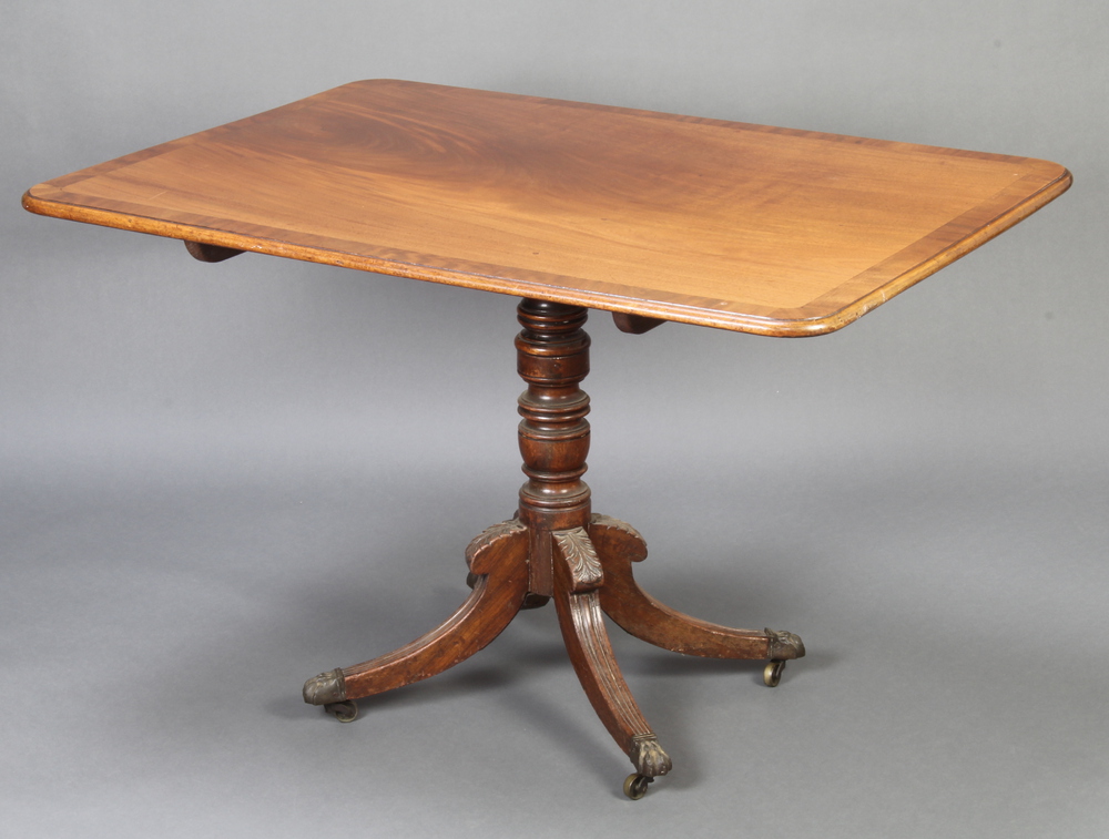 A Georgian rectangular, crossbanded mahogany snap top breakfast table, raised on a turned column and