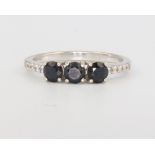 A 9ct white gold 3 stone sapphire ring with diamond shoulders, size N, 2.2 grams