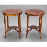 A pair of Edwardian circular inlaid mahogany 2 tier occasional tables raised on outswept supports