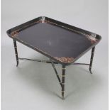 A 19th Century style rectangular lacquered tray raised on a black and gilt painted bamboo effect