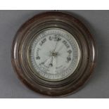 An aneroid barometer with silvered dial, contained in a gilt metal case 4cm x 27cm diam. The glass