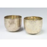 A pair of Georgian white metal tumbling cups of plain form 6cm, 397 grams The hallmarks are very