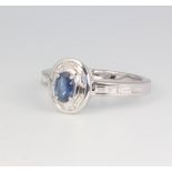 An 18ct white gold oval sapphire and diamond ring, sapphire approx. 0.45ct, the baguette cut