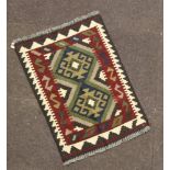 A brown and black ground Maimana Kilim rug with 2 stylised diamonds to the centre 180cm x 58cm