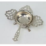 A silver tea strainer and stand London 1979, another tea strainer 144 grams