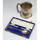 A silver mug of plain form with C scroll handle and engraved monogram Birmingham 1922 together