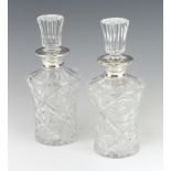 A pair of waisted cut glass spirit decanters with silver collars, London 1967, 22cm