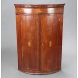 A Georgian inlaid mahogany bow front hanging corner cabinet enclosed by panelled doors 105cm h x