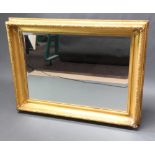 A 19th Century rectangular/cushion shaped gilt mirror frame containing a later bevelled plate mirror