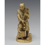 A Japanese carved ivory Meiji period Okimono of a fruit seller with a child and dog 14cm There is