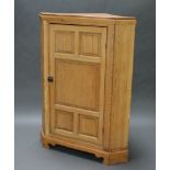 A Victorian pine corner cabinet with moulded cornice, fitted adjustable shelves enclosed by panelled