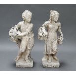 A pair of well weathered reconstituted stone classical figures of a boy and girl with baskets of