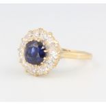 An 18ct yellow gold sapphire and diamond cluster ring, the centre brilliant cut sapphire approx. 1.