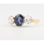 An 18ct. yellow gold 3 stone sapphire and diamond ring, the centre oval cut sapphire approx. 1.25ct,