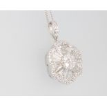 An 18ct white gold diamond floral pendant comprising brilliant and tapered baguette cut stones on