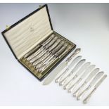 A cased set of 12 silver handled lily pattern dinner knives together with a ditto bread knife, 6