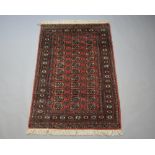 A pink and white ground Bokhara rug with 36 octagons to the centre 180cm x 123cm Some wear to the