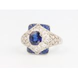 A Victorian style platinum diamond and sapphire cocktail ring set with an oval sapphire surrounded