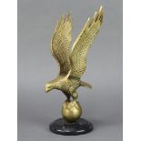 A brass figure of an albatross upon a globe, raised on a black marble socle base 27cm x 10cm