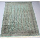 A green ground Bokhara carpet having 138 octagons to the centre within a multi row border 286cm x