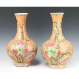 A pair of Antique style peach ground baluster vases decorated with fruits, 6 character mark to the