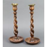 A pair of 1930's oak spiral turned candlesticks with detachable brass sconces 31cm h x 12cm diam.