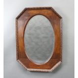 A 1930's oval bevelled plate wall mirror contained in a carved oak shaped frame 77cm h x 56cm w
