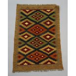A brown, black and green ground Maimana Kilim rug with overall geometric design 94cm x 61cm