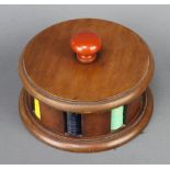 A cylindrical Art Deco mahogany game counter bank comprising 191 circular coloured plastic