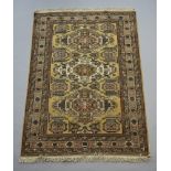 A Caucasian style rug with 3 medallions to the centre within a multi row border 196cm x 137cm