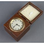 A 1930's travelling timepiece with silvered dial and Arabic numerals contained in a leather finished