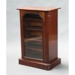 A Victorian inlaid walnut music cabinet with shelved interior enclosed by a shaped glazed panelled