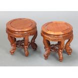 A very near pair of 20th Century circular Chinese carved hardwood jardiniere stands, raised on