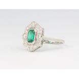 A platinum emerald and diamond cluster ring, the centre stone 1.05ct surrounded by brilliant cut