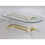 A mid Century gilt metal perspex and plate glass oval coffee table, raised on a shaped base 41cm h x