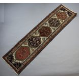 A blue and white ground Persian runner with 5 diamonds to the centre 280cm x 78cm