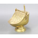 Benham, a Victorian embossed brass helmet shaped coal scuttle complete with shovel, the base with