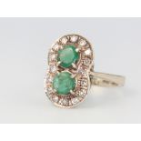 A white metal (marked 750) emerald and diamond double cluster ring, 7 grams, size O 1/2