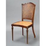 An Edwardian Georgian style carved mahogany bedroom chair with woven cane seat and back, raised on