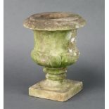 A well weathered carved stone urn, raised on a square base 21cm h x 11cm w x 11cm d Slight chip
