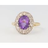 An 18ct yellow gold oval amethyst and diamond cluster ring, 4.4 grams, size M 1/2